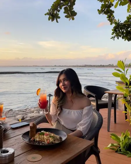 Unwind and relish your favorite drink at New Beach Club in Kuta, Bali, while watc