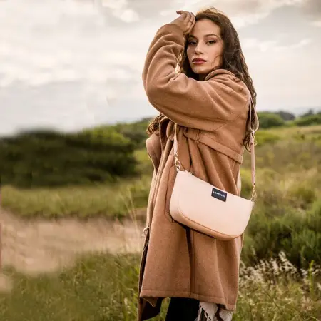 The STATUS neoprene bag features a crescent silhouette, a sophisticated day-to-